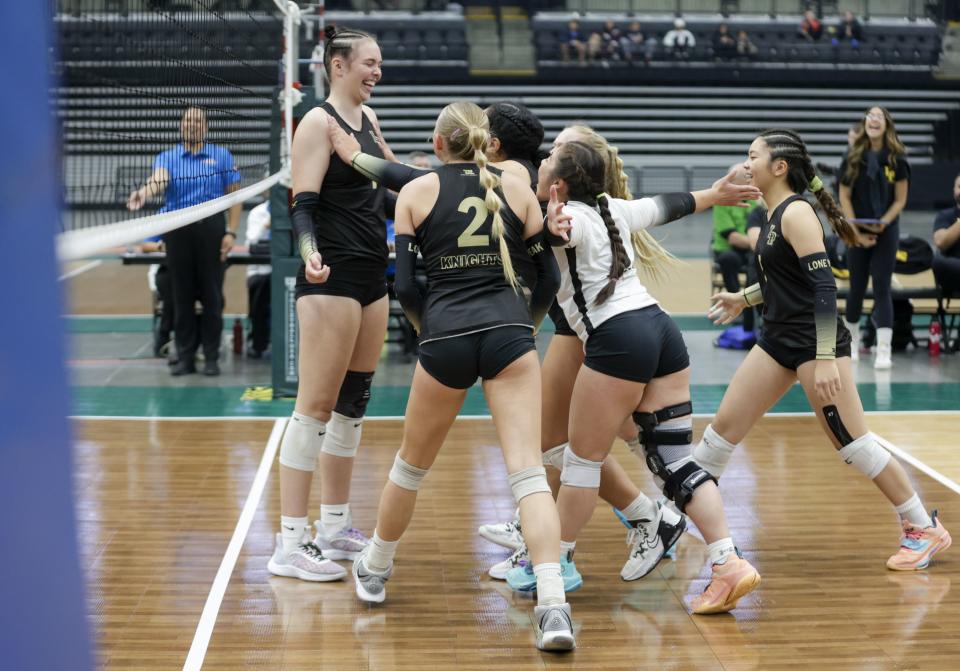 The Lone Peak Knights celebrate around Zoey Burgess after scoring a point against the Mountain Ridge Sentinels in the 6A finals in Orem on Saturday, Nov. 5, 2022. The Lone Peak Knights won 3-1 in sets. | Ben B. Braun, Deseret News