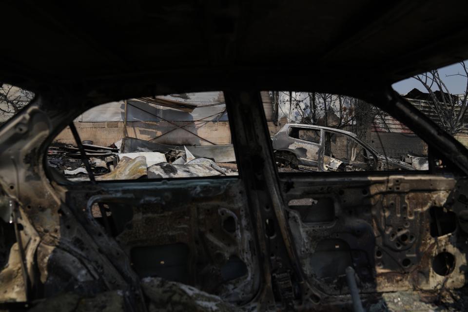 Burnt cars are visible after yesterday's fire in Mandra west of Athens, on Wednesday, July 19, 2023. (AP Photo/Thanassis Stavrakis)