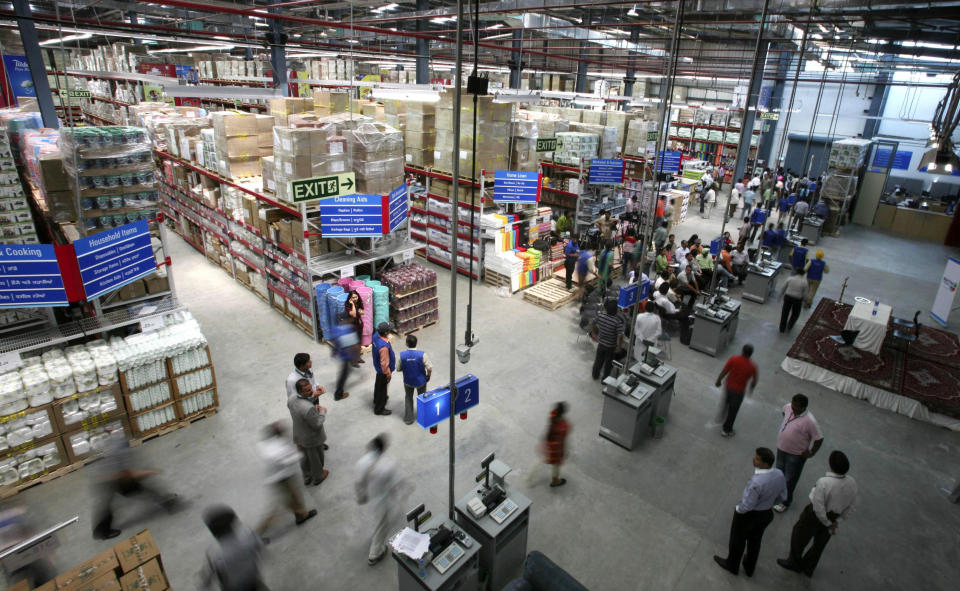 FILE - In this May 30, 2009 file photo, people gather for the inauguration ceremony of the first Wal-Mart/Bharti Enterprises joint venture store in Amritsar, India. India agreed Friday, Sept. 14, 2012 to open its huge market to foreign retailers such as Wal-Mart as part of a flurry of economic reforms aimed at sparking new growth in the sputtering economy. (AP Photo/Altaf Qadri, File)