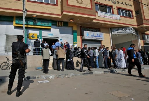 Palestinians line up to receive their salaries in Rafah in the southern Gaza Strip