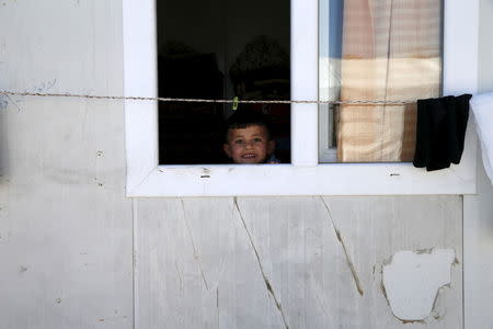 Yazidi boy Emad, 5, looks out of his family's home at a refugee camp near the northern Iraqi city of Duhok April 19, 2016. REUTERS/Ahmed Jadallah