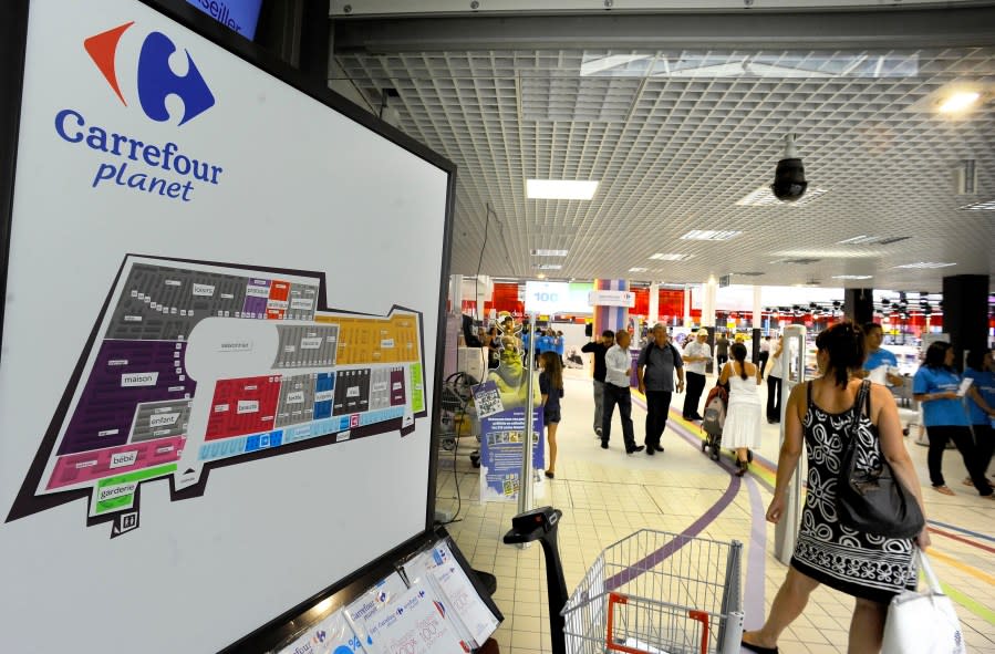 FILE – Shoppers enter the new Carrefour store Wednesday Aug. 25, 2010 in Ecully, near Lyon, central France. Carrefour has unveiled its hypermarket reinvention project at two stores in Lyon. The Ecully and Venissieux host the Carrefour Planet concept. The stores split into nine zones, including a ‘discovery’ store for events and seasonally themed products. (AP Photo/Thomas Campagne, File)