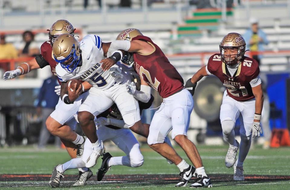 Mainland running back Rodney Hill tries to fight off a St. Augustine tackler during the Class 3S state championship game on Thursday in Tallahassee.