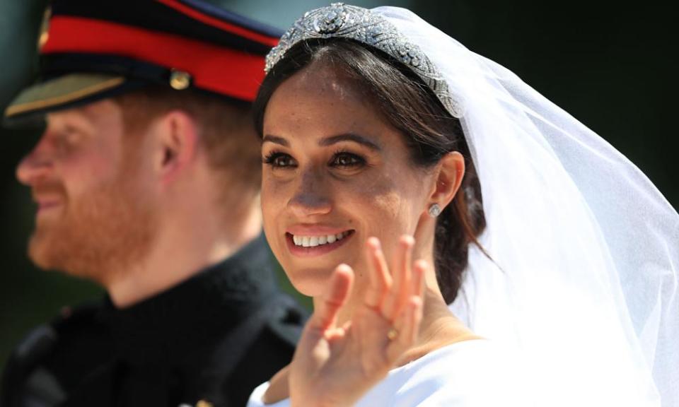 Prince Harry and Meghan Markle ride in a horse-drawn carriage after their wedding.