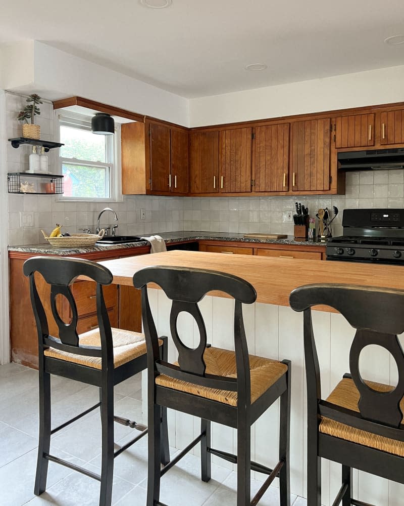 Bar stools lined up under kitchen countertops in newly renovated kitchen.