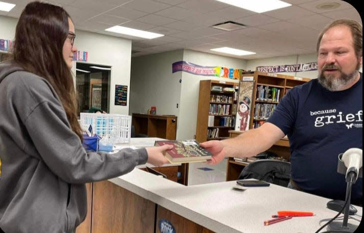 Saegertown High School Senior Ella Worley returns “To Kill a Mockingbird” to librarian Mike Brenneman on the morning of Jan. 20, 2023. Teachers received an email directing them to send several students to the library with their books. Photo by Panther Press photo and design editor Luthea Sweeney, 18.