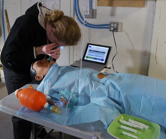 Journalist Elizabeth Howell inserts a laryngoscope in a mannequin as part of a procedure to simulate giving anesthesia for a patient. Howell was on site at Utah's Mars Desert Research Station.