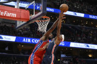 Philadelphia 76ers center Joel Embiid, left, fouls Washington Wizards guard Bradley Beal, right, during the first half of an NBA basketball game, Monday, Jan. 17, 2022, in Washington. (AP Photo/Nick Wass)