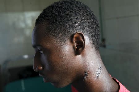 Alassane Diallo, 17, a supporter of presidential candidate Cellou Dalein Diallo, sits on a bed at a clinic after being wounded on his neck by a bullet during clashes between security forces and opposition supporters, in Conakry October 14, 2015. REUTERS/Luc Gnago