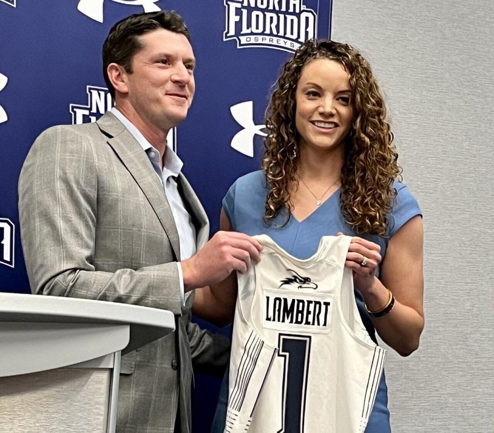 University of North Florida women's basketball coach Erika Lambert is given an Ospreys basketball jersey by UNF athletic director Nick Morrow after her first news conference following her hiring on April 21, 2023.