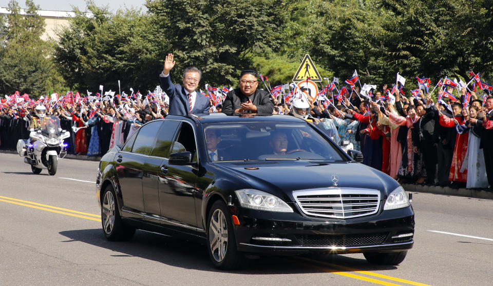 South Korean President Moon Jae-in, left, and North Korean leader Kim Jong-un ride in a car parade through Pyongyang in North Korea, Tuesday, Sept. 18, 2018. (Pyongyang Press Corps Pool via AP)