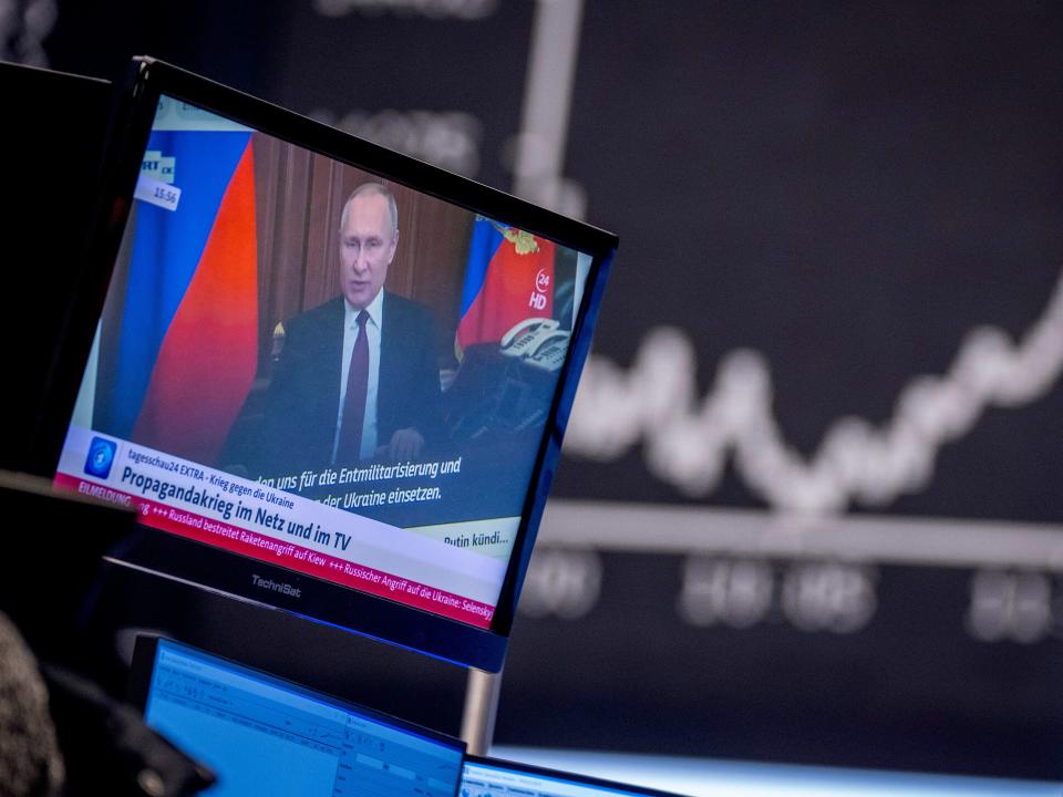 Vladimir Putin appears on a television screen.