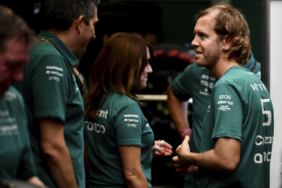 Aston Martin driver Sebastian Vettel of Germany is surrounded with members of his team at the Hungaroring racetrack in Mogyorod, near Budapest, Hungary, Thursday, July 28, 2022. Four-time Formula One champion Sebastian Vettel says he will retire at the end of the season to spend more time with his family. The Hungarian Formula One Grand Prix will be held on Sunday. (AP Photo/Anna Szilagyi)