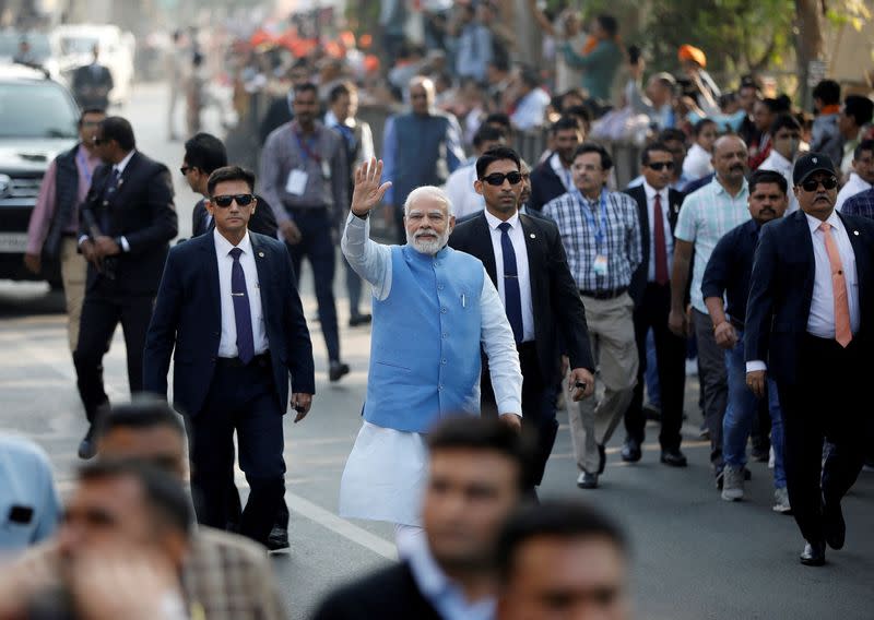 FILE PHOTO: PM Modi waves to his supporters as he arrives to cast his vote, in Ahmedabad