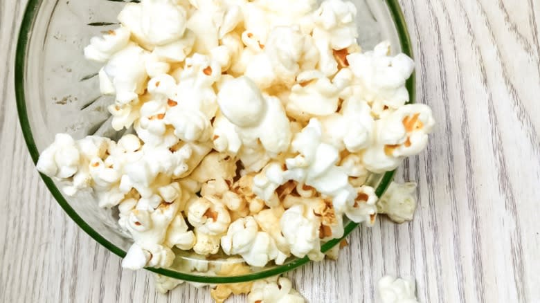 Popcorn in a bowl on wood surface