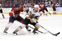 Vegas Golden Knights defenseman Shea Theodore (27) skates with the puck as Florida Panthers center Frank Vatrano (77) pursues during the second period of an NHL hockey game, Thursday, Jan. 27, 2022, in Sunrise, Fla. (AP Photo/Lynne Sladky)