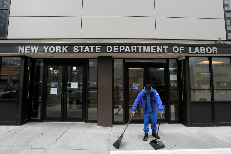 A person sweeps outside the entrance of the New York State Department of Labor offices, which closed to the public due to the coronavirus disease (COVID-19) outbreak in the Brooklyn borough of New York City, U.S., March 20, 2020. REUTERS/Andrew Kelly