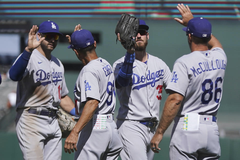 Los Angeles Dodgers' Joey Gallo, left, third base coach Dino Ebel, Cody Bellinger and first base coach Clayton McCullough (86) celebrate after the Dodgers defeated the San Francisco Giants in a baseball game in San Francisco, Thursday, Aug. 4, 2022. (AP Photo/Jeff Chiu)