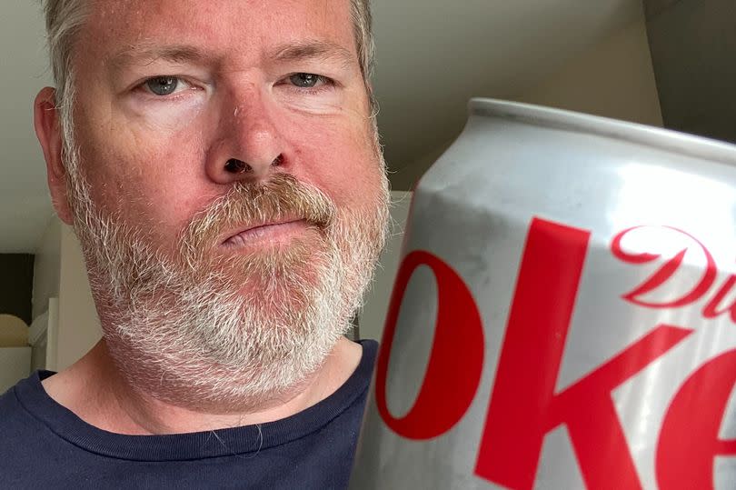 Man holding a can of Diet Coke