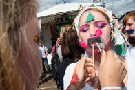 BERLIN, GERMANY - JULY 21: A teammate prepares a contestant for the make-your-own-ironic-Hipster-moustache competition at the second annual Hipster Olympics on July 21, 2012 in Berlin, Germany. With events such as the "Horn-Rimmed Glasses Throw," "Skinny Jeans Tug-O-War," "Vinyl Record Spinning Contest" and "Cloth Tote Sack Race," the Hipster Olympics both mocks and celebrates the Hipster subculture, which some critics claim could never be accurately defined and others that it never existed in the first place. The imprecise nature of determining what makes one a member means that the symptomatic elements of adherants to the group vary in each country, but the archetype of the version in Berlin, one of the more popular locations for those following its lifestyle, along with London and Brooklyn, includes a penchant for canvas tote bags, the carbonated yerba mate drink Club Mate, analogue film cameras, asymetrical haircuts, 80s neon fashion, and, allegedly, a heavy dose of irony. To some in Berlin, members of the hipster "movement" have replaced a former unwanted identity in gentrifying neighborhoods, the Yuppie, for targets of criticism, as landlords raise rents in the areas to which they relocate, particularly the up-and-coming neighborhood of Neukoelln. (Photo by Adam Berry/Getty Images)