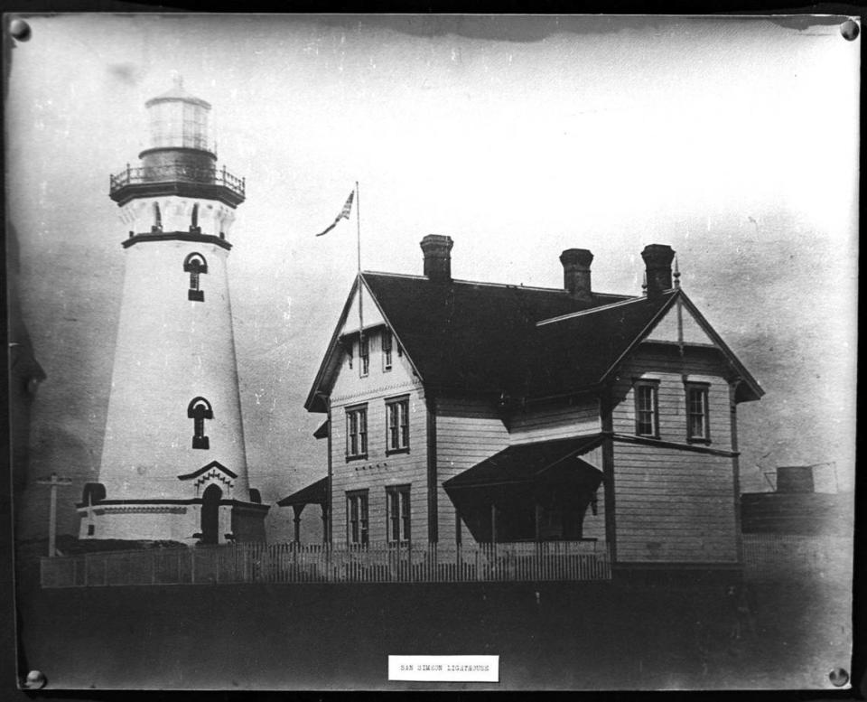 A historic photo shows the Piedras Blancas Light Station grounds as it looked when the lighthouse was in operation. The lightkeepers dwelling in the foreground has been removed and is now a private residence in Cambria. Most of these older structures have been removed or torn down to make way for modern living quarters for the Coast Guard force manning the station and their families. This old photograph was provided by the San Luis Obispo County Museum and is from the Irene Carpenter Collection of Historic San Luis Obispo County pictures. Copy negative made in 1963.