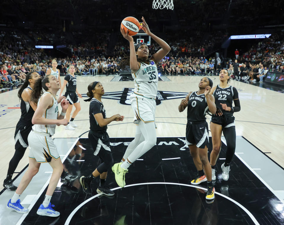 LAS VEGAS, NEVADA – JUNE 15: Jonquel Jones #35 of the New York Liberty scores a layup between Sydney Colson #51 and Jackie Young #0 of the Las Vegas Aces during the third quarter of their game at Michelob ULTRA Arena on June 15. 2024 in Las Vegas, Nevada. The Liberty defeated the Aces 90-82. NOTE TO USER: User expressly acknowledges and agrees that by downloading and/or using this photograph, User is agreeing to the terms and conditions of the Getty Images License Agreement. (Photo by Ethan Miller/Getty Images)