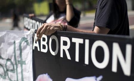 An activist holds a rosary while ralling against abortion outside City Hall in Los Angeles, California September 29, 2015. REUTERS/Mario Anzuoni