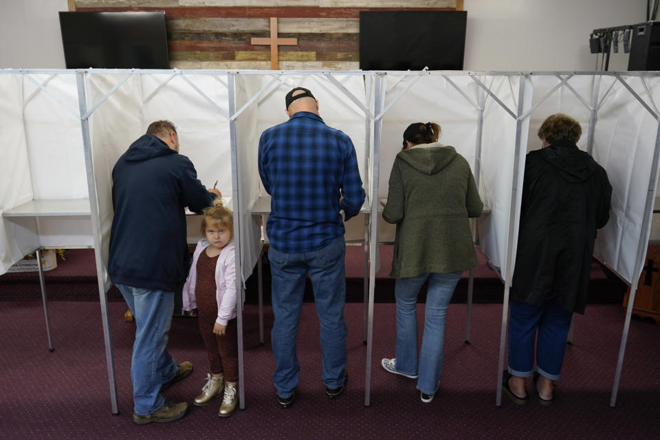 Pennsylvania Republican gubernatorial candidate Doug Mastriano, third from right, his wife Rebecca, second from right, and Christopher Burch with his daughter Sophia Burch, 4, left, vote at their polling place, the New LIFE Worship Center Church of God, in Fayetteville, Pa., Tuesday, Nov. 8, 2022. (AP Photo/Carolyn Kaster)