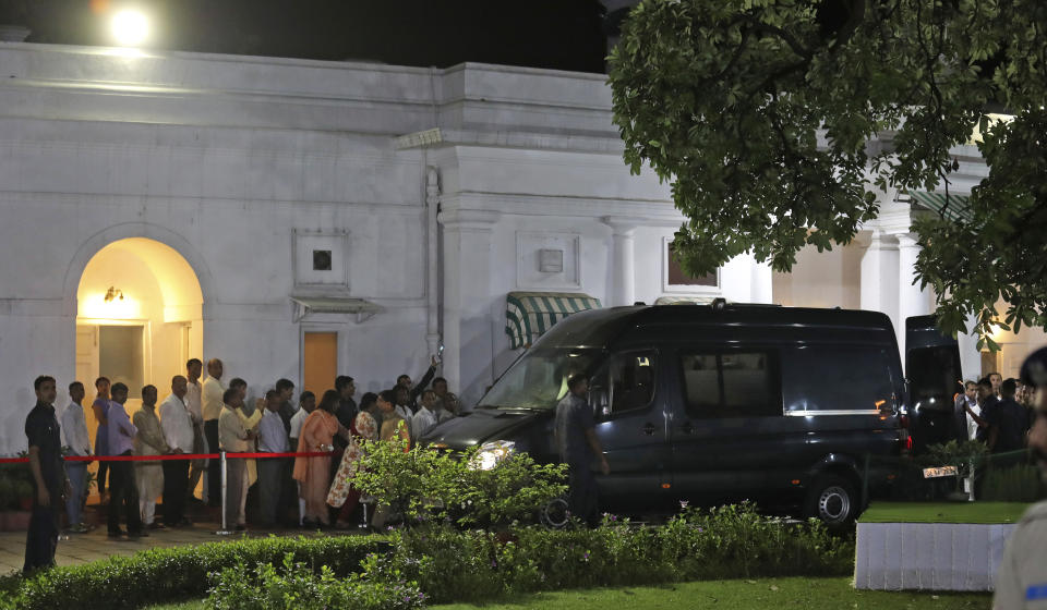 An ambulance carrying the body of former Indian prime minister Atal Bihari Vajpayee arrives at his residence in New Delhi, India, Thursday, Aug. 16, 2018. Vajpayee, a Hindu nationalist who set off a nuclear arms race with rival Pakistan but later reached across the border to begin a groundbreaking peace process, died on Thursday after a prolonged illness. He was 93. (AP Photo/Manish Swarup)