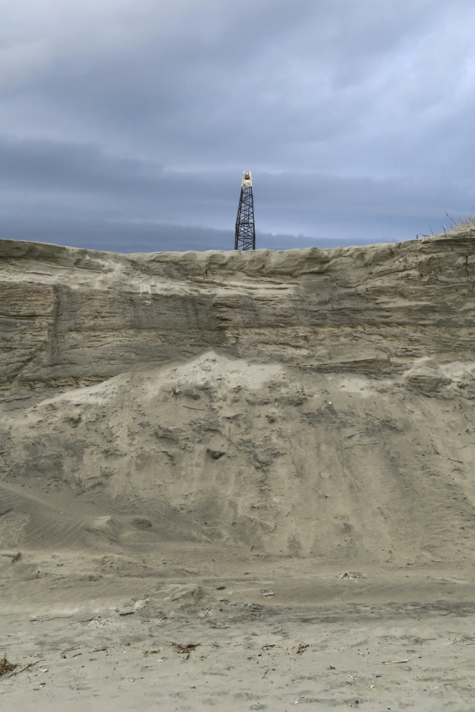 A construction crane rises above an eroded beach in North Wildwood, N.J., Jan. 5, 2023. A judge on Feb. 1, 2023, denied the city permission to build a bulkhead to protect against erosion, but allowed it to move forward with a $21 million lawsuit seeking damages from the state to recoup the cost of sand the city trucked in at its own expense in the absence of a state and federal beach replenishment project. (AP Photo/Wayne Parry)