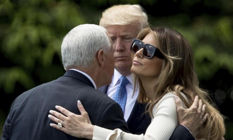 Melania Trump and Mike Pence embrace as they walk across the South Lawn of the White House on Friday.