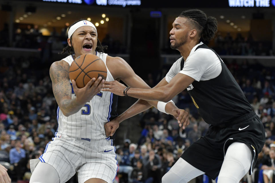 Orlando Magic forward Paolo Banchero (5) handles the ball against Memphis Grizzlies forward Ziaire Williams, right, in the second half of an NBA basketball game Friday, Jan. 26, 2024, in Memphis, Tenn. (AP Photo/Brandon Dill)