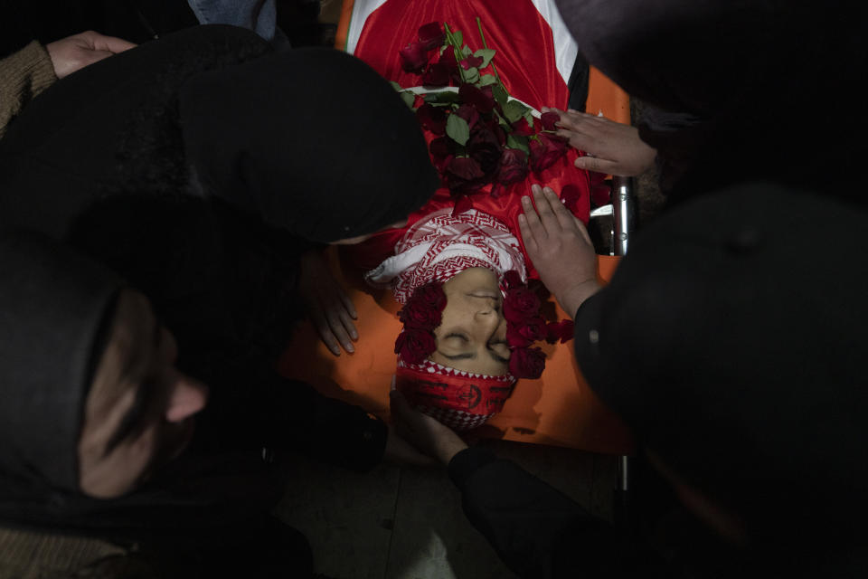 Palestinian mourners take the last look at the body of Suleiman Kanan, 17, during his funeral in the West Bank town of Bir Zeit, Monday, Jan. 15, 2024. Palestinian Health Ministry said that Suleiman Kanan, 17, and Khaled Humeidat, 16, were killed by Israeli army fire last night near the northern entrance of Ramallah. Humeidat's body was not released to his family by the Israeli army. The Israeli army said troops of the 636th Combat Intelligence Collection unit carrying out "proactive activity" near Ramallah killed two suspects hurling a bomb at the army base. (AP Photo/Nasser Nasser)