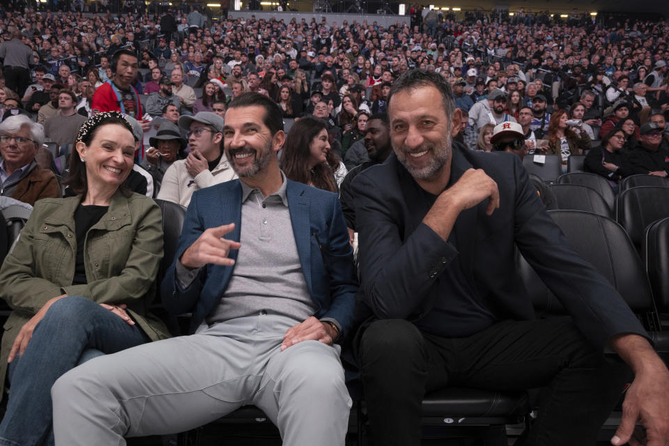 Matina Kolokotronis, left, chief operating officer of the Sacramento Kings, smiles with former NBA players Peja Stojakovic, center, and Vlade Divac, right, during a timeout in the first quarter of an NBA basketball game between the Kings and the Minnesota Timberwolves in Sacramento, Calif., Saturday, Dec. 23, 2023. (AP Photo/José Luis Villegas)