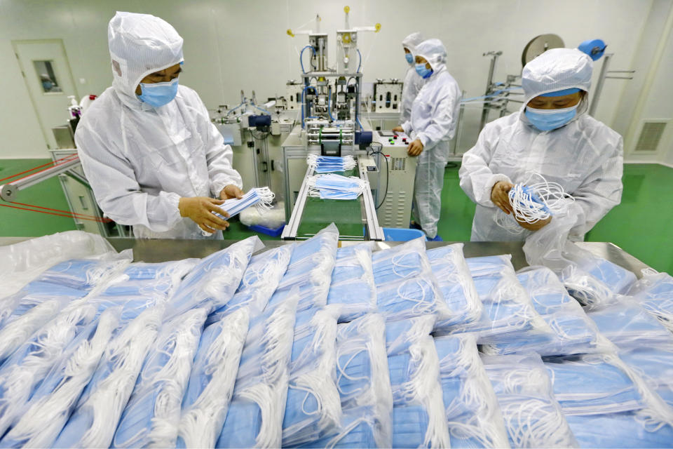 In this Friday, Feb. 7, 2020, photo, workers pack surgical masks at a factory in Suining city in southwest China's Sichuan province. The number of confirmed cases of the new virus has risen again in China on Saturday, as the ruling Communist Party faced anger and recriminations from the public over the death of a doctor who was threatened by police after trying to sound the alarm about the disease over a month ago. (Chinatopix via AP)