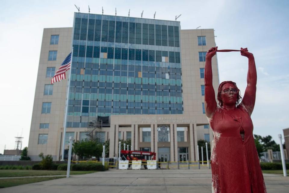 A protestor who would not provide her name stands in front of the Dan M. Russell Jr. Courthouse covered in red paint during a protest against the Supreme Court Dobbs vs Jackson Women’s Health decision that reversed Roe vs Wade in Gulfport on Friday, June 24, 2022. “The government does not own my body,” she said, “abortions will still happen but more will die.”