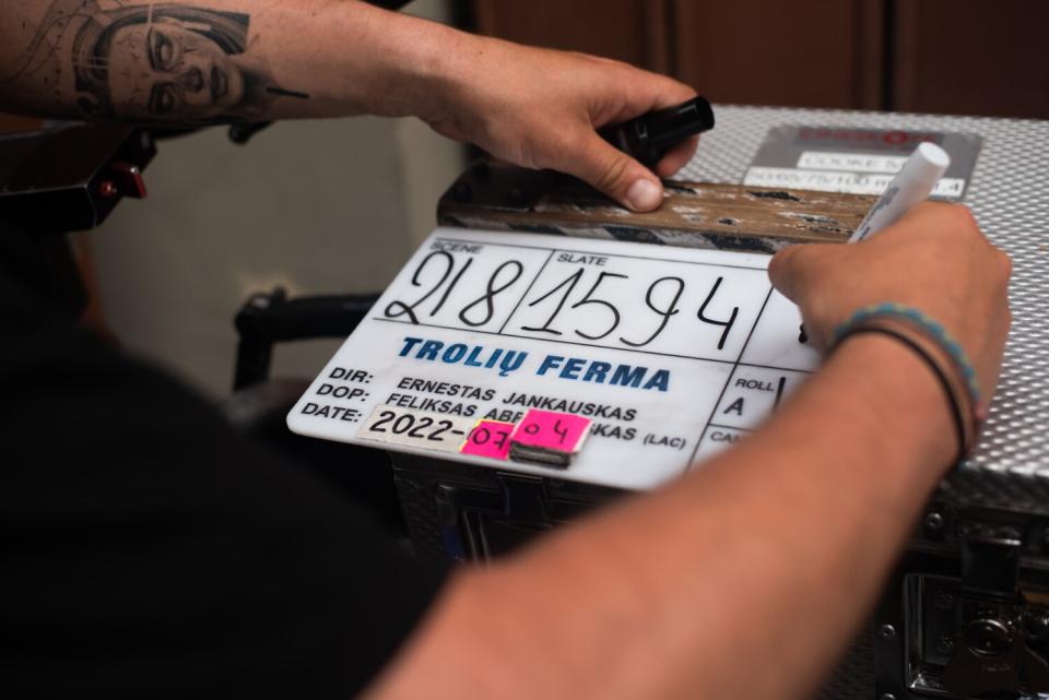 A man uses a marker to write on a sign.