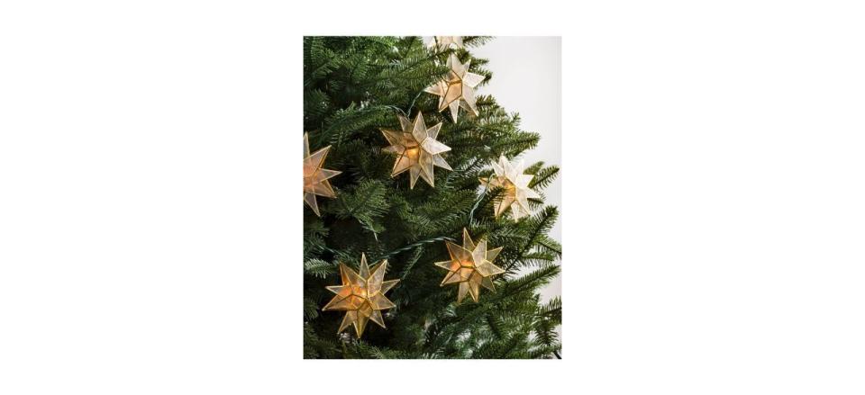 Balsam Hill Lit Capiz Star Garland on a Christmas tree