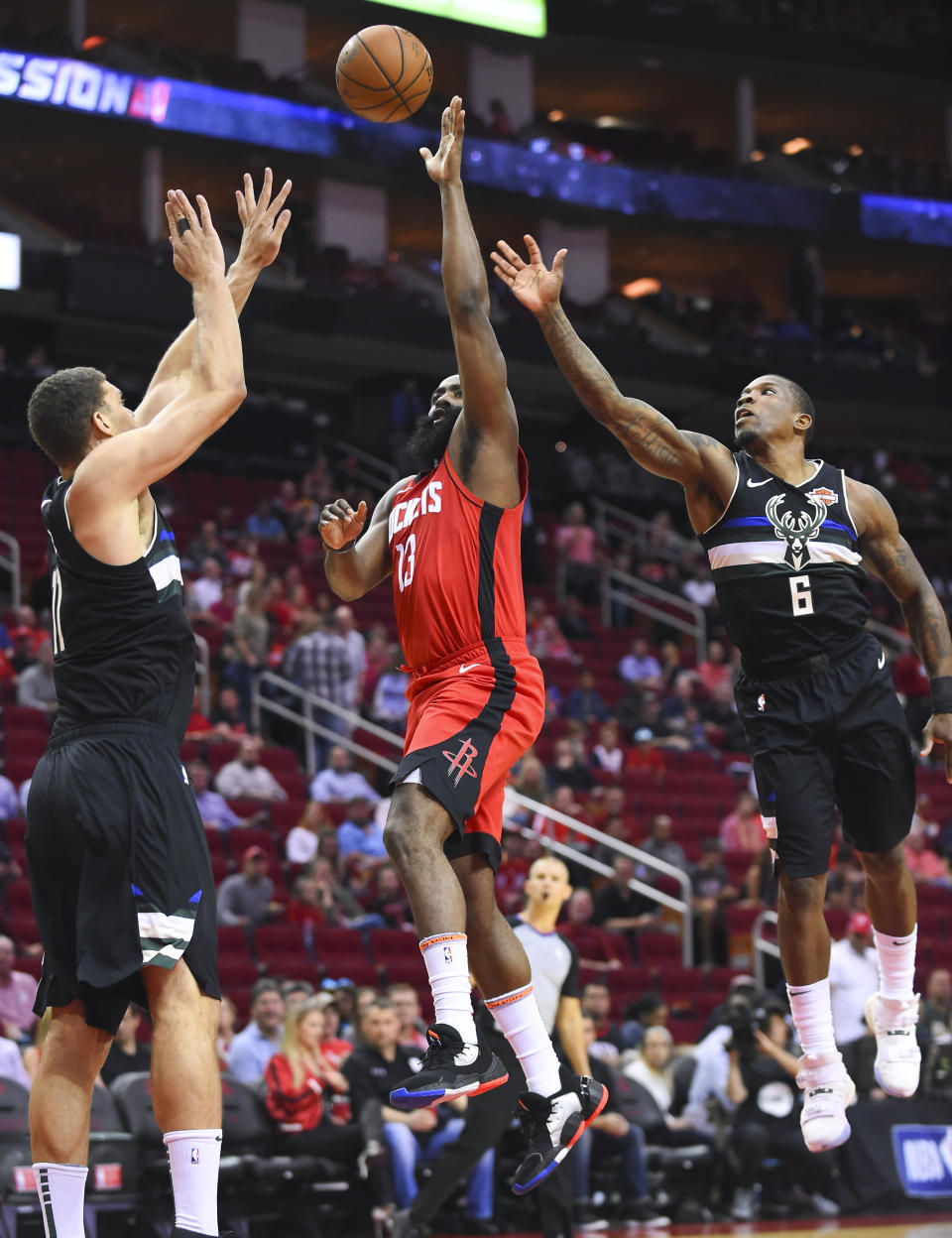 Houston Rockets guard James Harden, center, shoots as Milwaukee Bucks center Brook Lopez, left, and guard Eric Bledsoe defend during the first half of an NBA basketball game Thursday, Oct. 24, 2019, in Houston. (AP Photo/Eric Christian Smith)