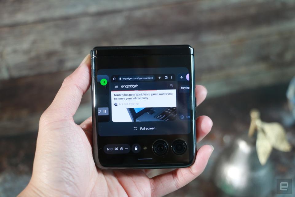 <p>The Motorola Razr+ folded shut and held in mid-air, with the Android open apps page on the display and the words "full screen" below each tile.</p>
