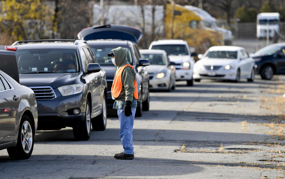 Reading, PA - December 15: A volunteer directs traffic as people wait in line in their cars to get food. During a food distribution held on the RACC (Reading Area Community College) campus along South Second Street with Helping Harvest, in Reading Tuesday afternoon December 15, 2020. Helping Harvest has seen an increase in need during the economic difficulties from the COVID-19 / Coronavirus Pandemic. (Photo by Ben Hasty/MediaNews Group/Reading Eagle via Getty Images)