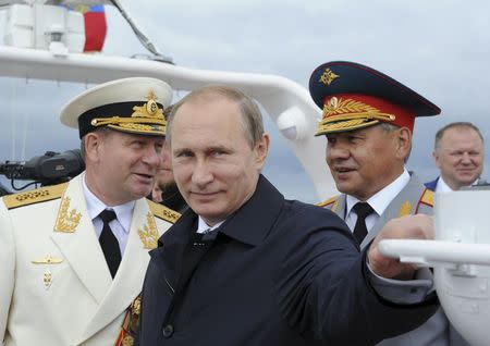 Russian President Vladimir Putin (C) and Defence Minister Sergei Shoigu (R) take part in celebrations for Navy Day in Baltiysk, Kaliningrad region, Russia, July 26, 2015. REUTERS/RIA Novosti/Mikhail Klimentyev/Kremlin