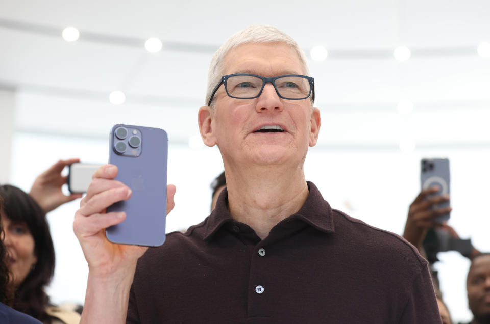 O CEO da Apple, Tim Cook, dá uma olhada no novo iPhone 14 Pro durante um evento da Apple.