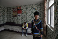 A Yi ethnic minority member stands inside his house displaying posters of Chinese President Xi Jinping and his wife Peng Liyuan, in Xujiashan village in Ganluo County, southwest China's Sichuan province, on Sept. 10, 2020. Communist Party Xi’s smiling visage looks down from the walls of virtually every home inhabited by members of the Yi minority group in a remote corner of China’s Sichuan province. Xi has replaced former leader Mao Zedong for pride of place in new brick and concrete homes built to replace crumbling traditional structures in Sichuan’s Liangshan Yi Autonomous Prefecture, which his home to about 2 million members of the group. (AP Photo/Andy Wong)