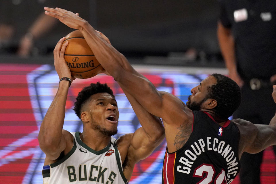 Milwaukee Bucks' Giannis Antetokounmpo (34) works to get a shot off as Miami Heat's Andre Iguodala (28) defends during the second half of an NBA basketball conference semifinal playoff game, Monday, Aug. 31, 2020, in Lake Buena Vista, Fla. (AP Photo/Mark J. Terrill)