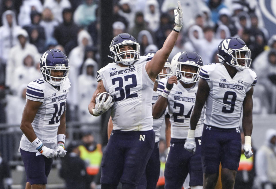 FILE - Northwestern linebacker Bryce Gallagher (32) celebrates after intercepting a Penn State pass during an NCAA college football game Oct. 1, 2022, in State College, Pa. Northwestern will not have any players at the Big Ten’s annual media days this week after the three who were scheduled to attend opted Tuesday, July 25, to back out because of hazing scandals that have engulfed the school. Gallagher, defensive back Rod Heard II and receiver Bryce Kirtz said in a statement they made the “very difficult” decision after consulting with interim coach David Braun, their parents and teammates. (AP Photo/Barry Reeger, File)