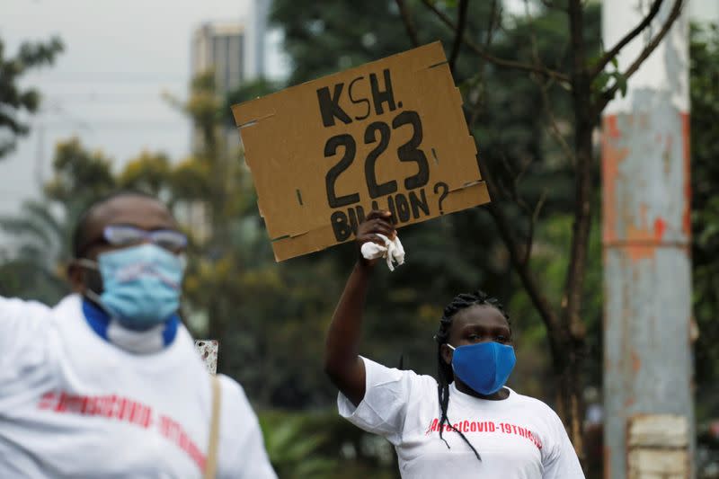 FILE PHOTO: A protester holds a placard during a demonstration against suspected corruption in the response of the Kenyan government to the coronavirus disease (COVID-19) outbreak in Nairobi