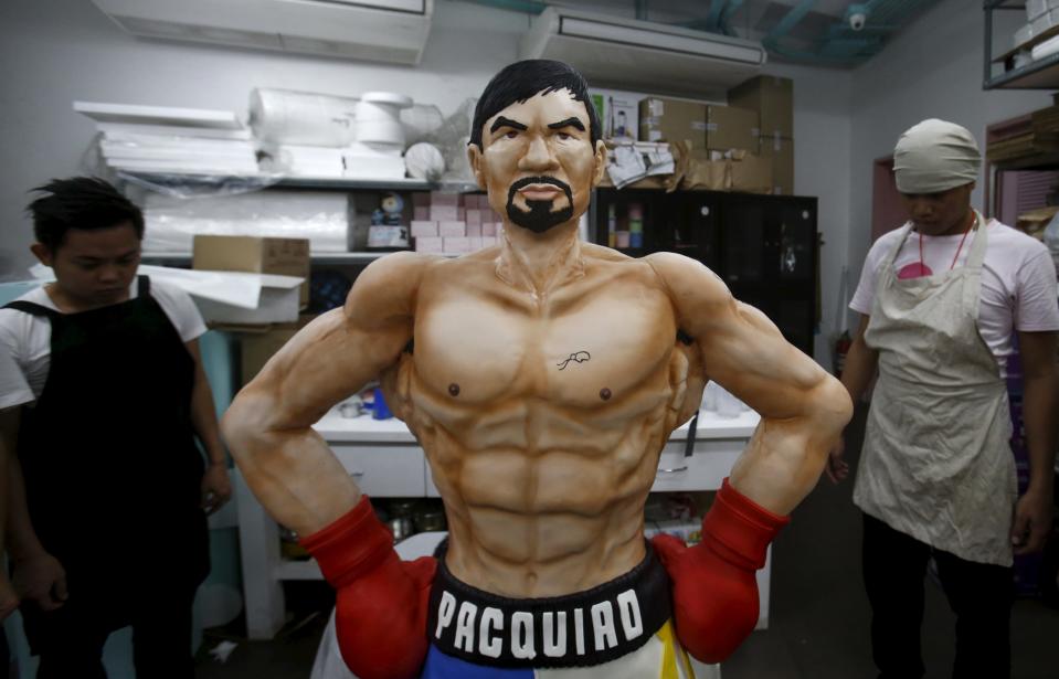 Workers from a bakery show a life-size 70-kg chocolate cake of local boxing icon Manny Pacquiao to the media in Manila, Philippines May 2, 2015. From air-conditioned corporate boardrooms to steamy public gymnasiums, Filipinos are counting down the hours to Pacquiao's fight with undefeated American Floyd Mayweather Jr. in Las Vegas. The world welterweight championship bout, which is being called the "fight of the century," will bring the country to a standstill on Sunday and mark a rare period of unity for the poor Southeast Asian nation. The Pacquiao cake, which took two weeks to make, went on display on Saturday in Manila and slices will be given away after the bout. REUTERS/Erik De Castro