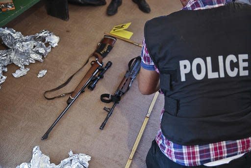 This Aug. 30, 2016, photo provided by Kosovo Police shows police officers seizing fire arms and bullets during a raid were Kosovo police have detained six people over their involvement with an attack with an explosive device at the parliament building earlier this month. The Aug. 4 attack damaged the buildings exterior but no one was injured. The local media have identified the suspects as members or supporters of the VETEVENDOSJE opposition party that is opposed to planed border demarcation deal with Montenegro. ( Kosovo Police via AP)