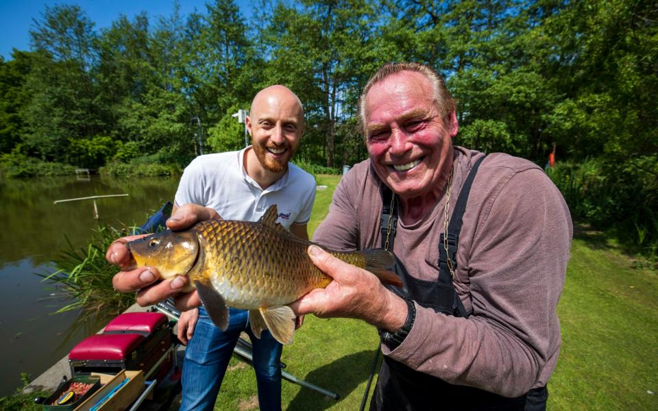 Telegraph reporter Ben Bloom is given his first fishing lesson by former darts player - JAMIE LORRIMAN
